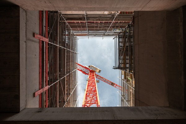 roter Kran von unten durch einen Schacht fotografiert