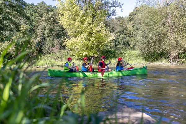 Vier Personen sitzen im Kanu auf dem Wasser