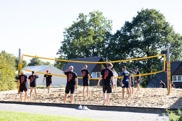 Personen spielen Volleyball auf dem Volleyballfeld im Freien